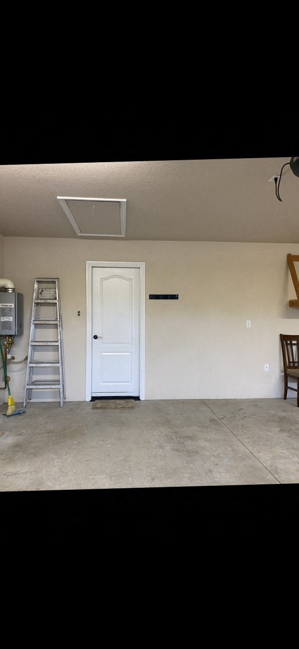 an empty room with a white door and a ladder