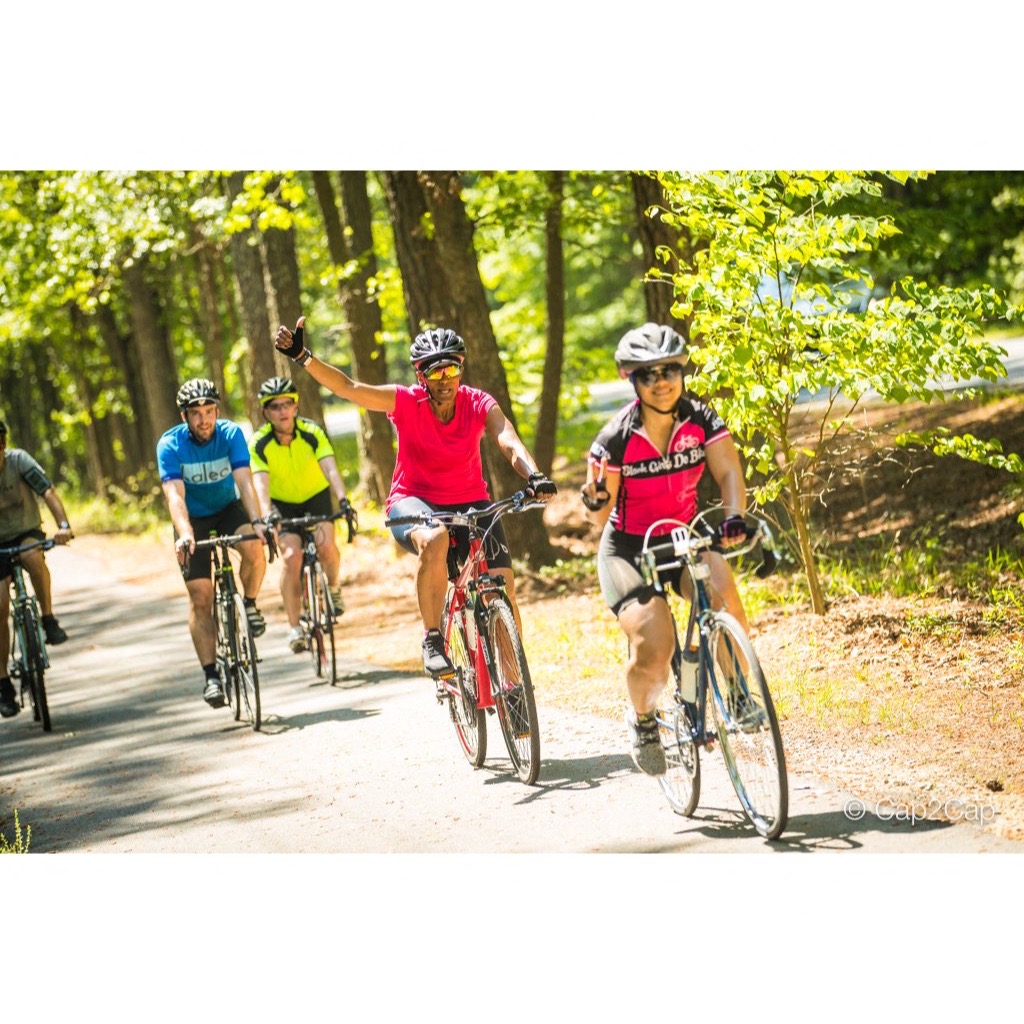 a group of people riding bikes down a dirt road