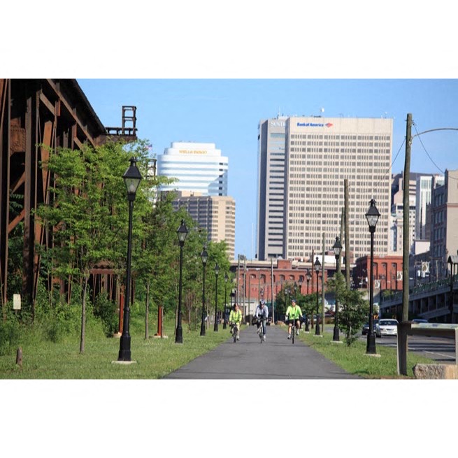 people riding bikes down a city street with tall buildings