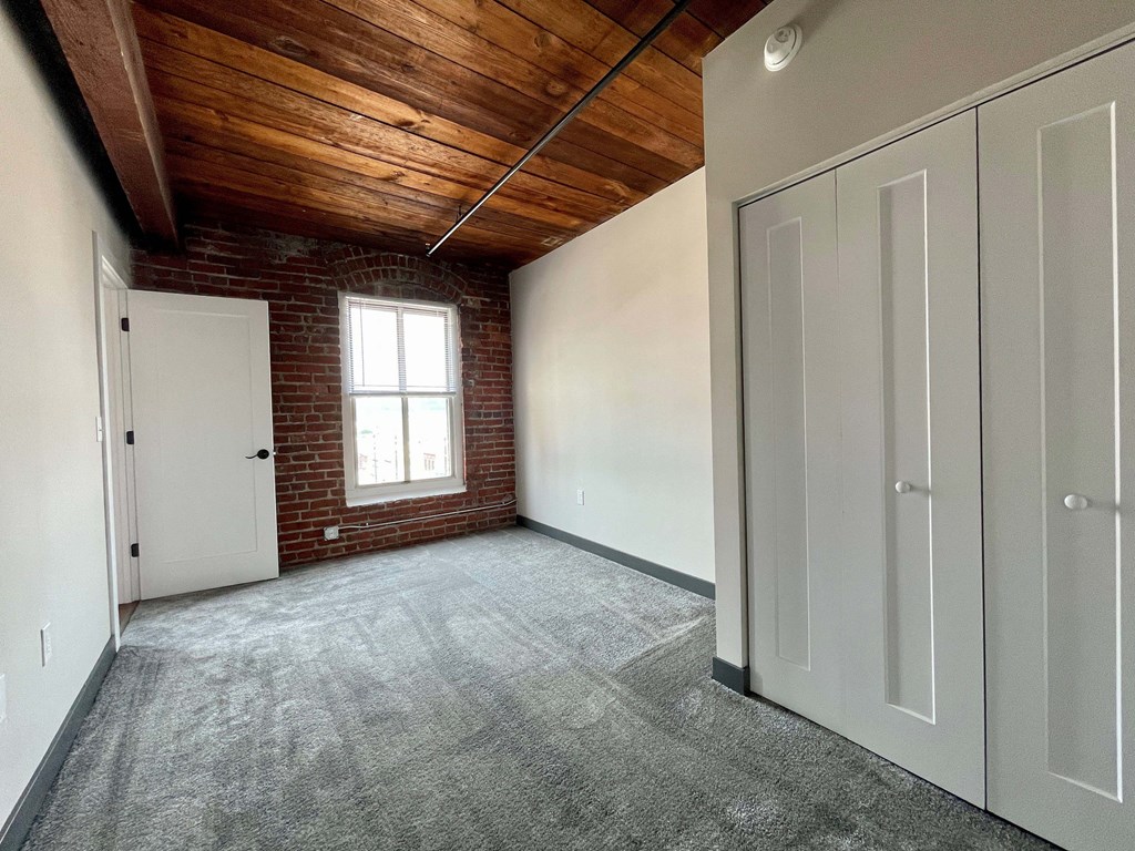 an empty room with a window and white doors