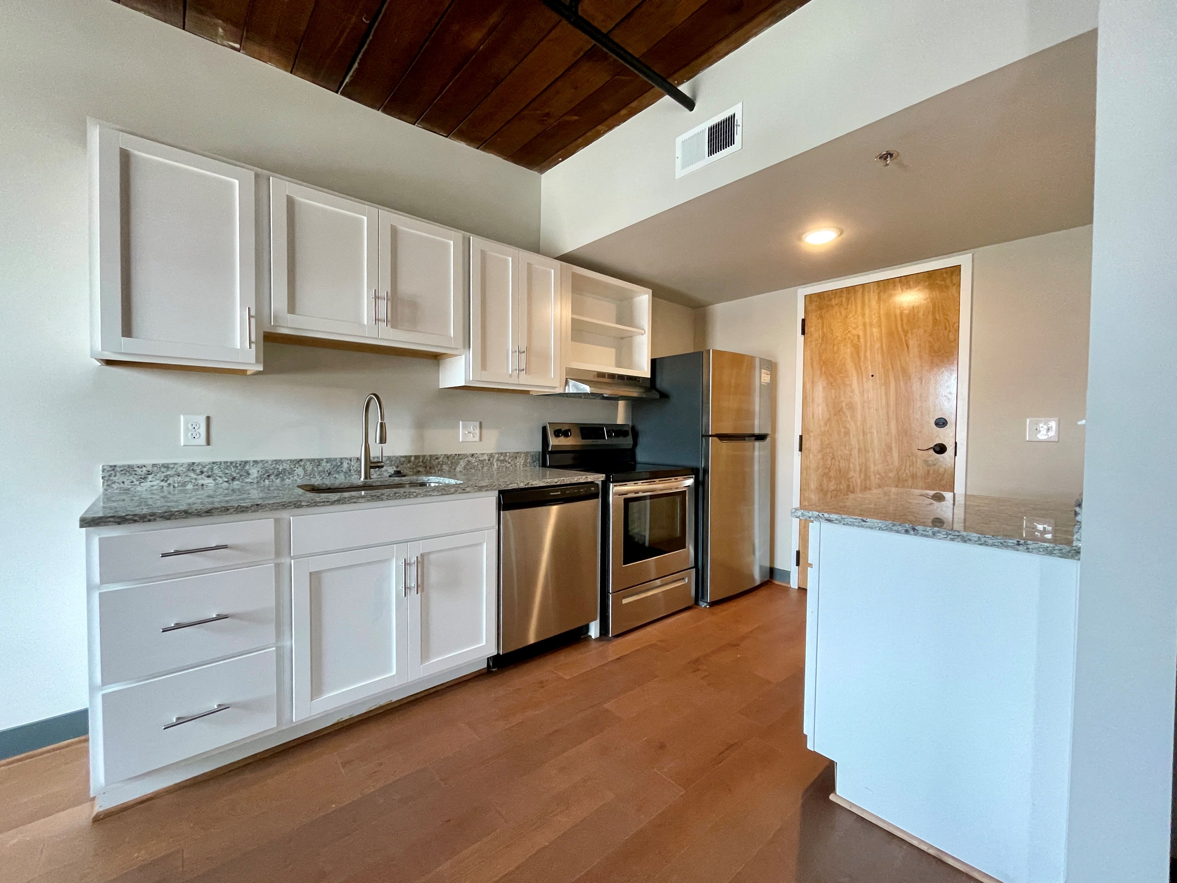 a kitchen with white cabinets and stainless steel appliances