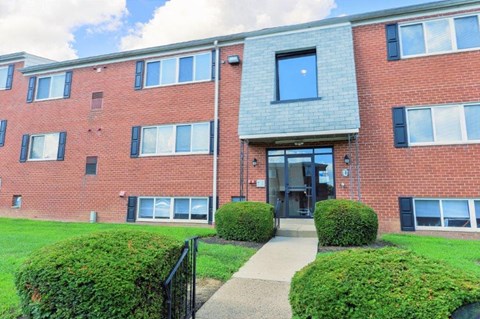 the front of a brick building with a sidewalk in front of it