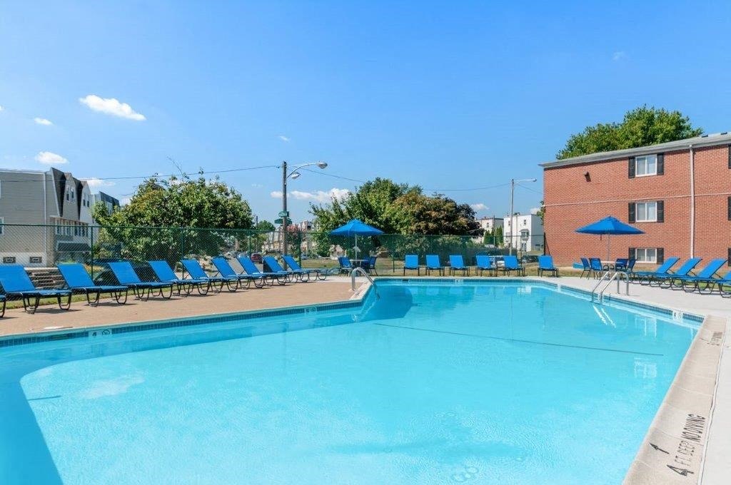 a swimming pool with blue lounge chairs around it