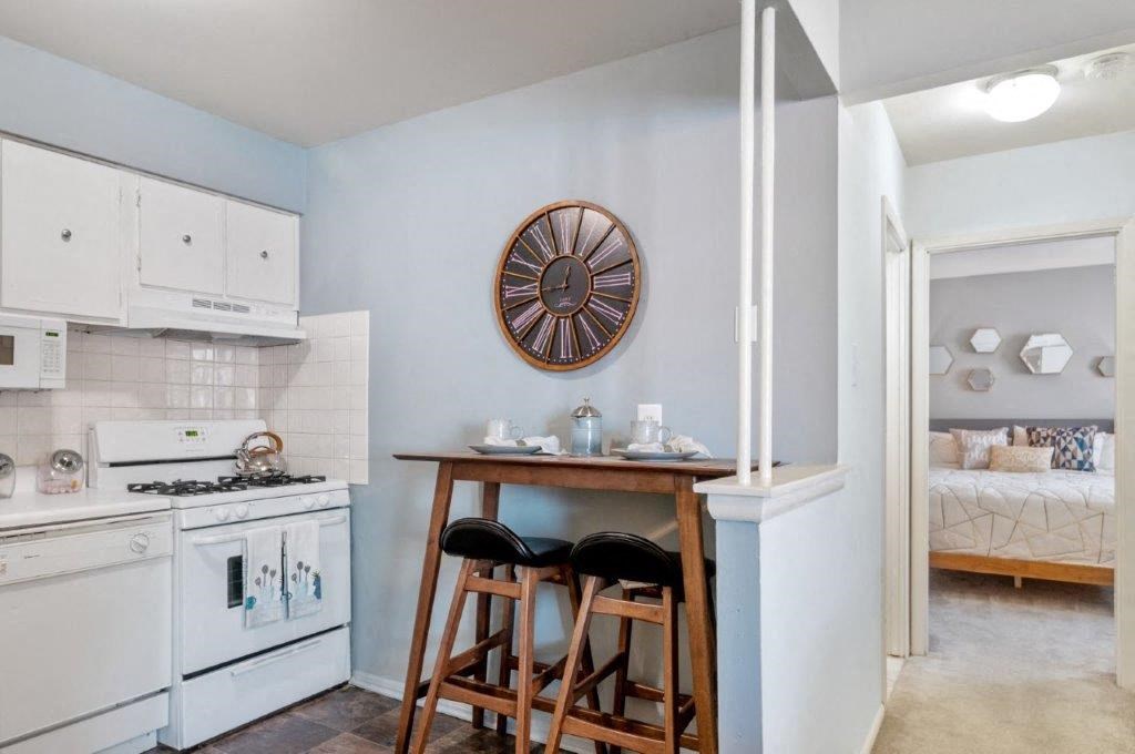 a kitchen with a table and a stove and a sink