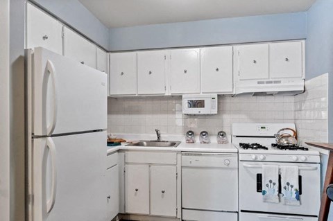 a white kitchen with white appliances and white cabinets