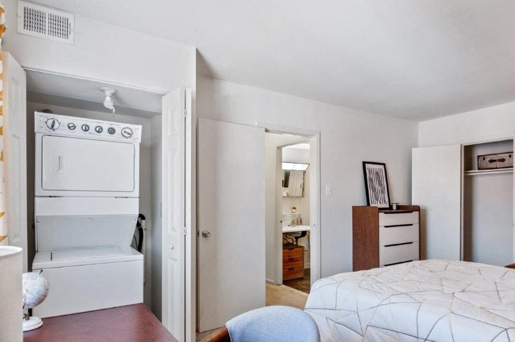 a bedroom with a bed and a white stove and refrigerator