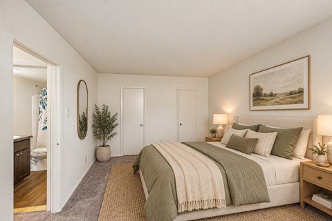 A bedroom with a large bed and a painting on the wall.