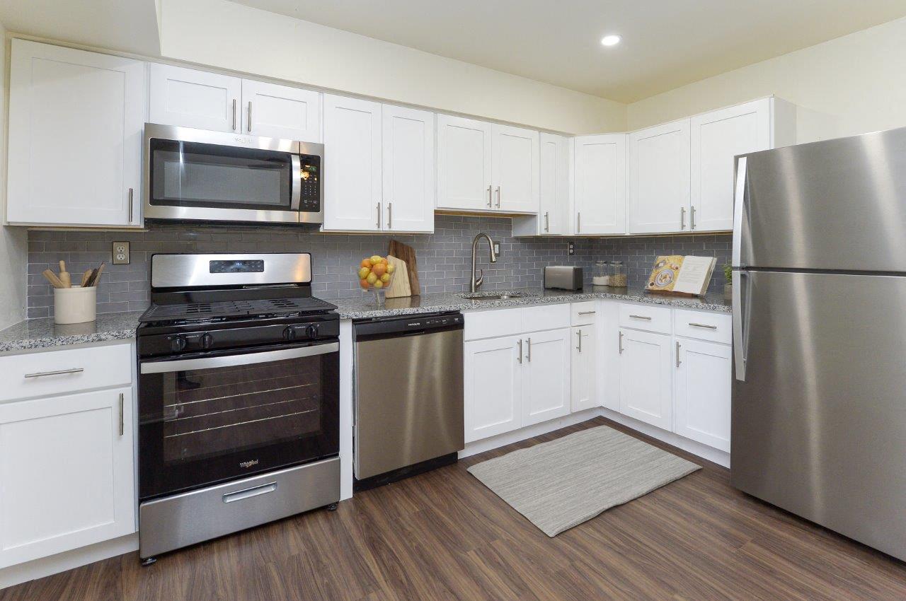 A kitchen with white cabinets and stainless steel appliances.