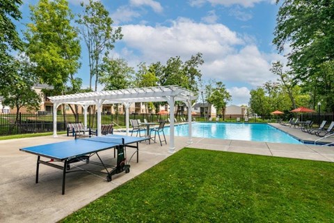 a swimming pool with tables and a ping pong table