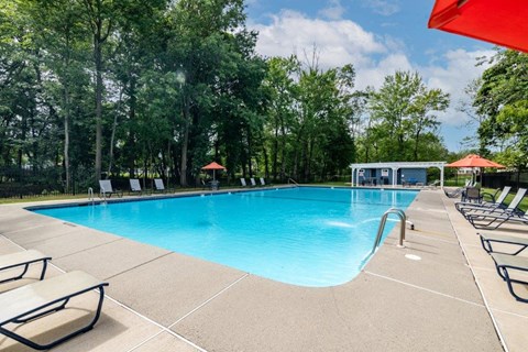 a swimming pool surrounded by chairs and umbrellas