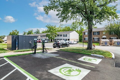 an electric charging station in a parking lot in front of an apartment building