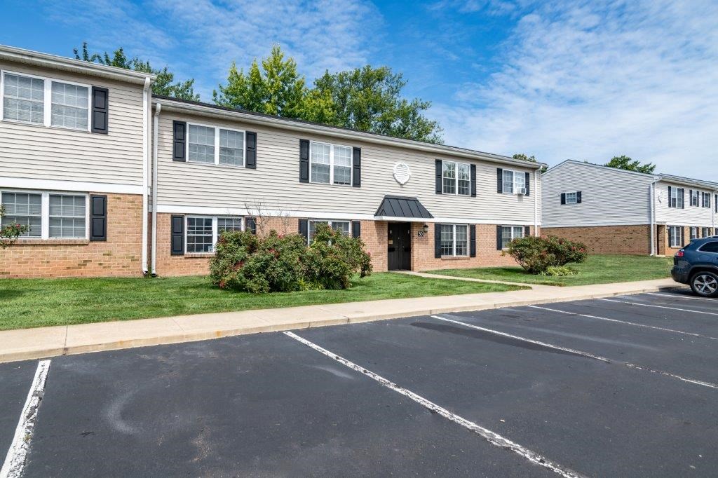 an empty parking lot in front of an apartment building