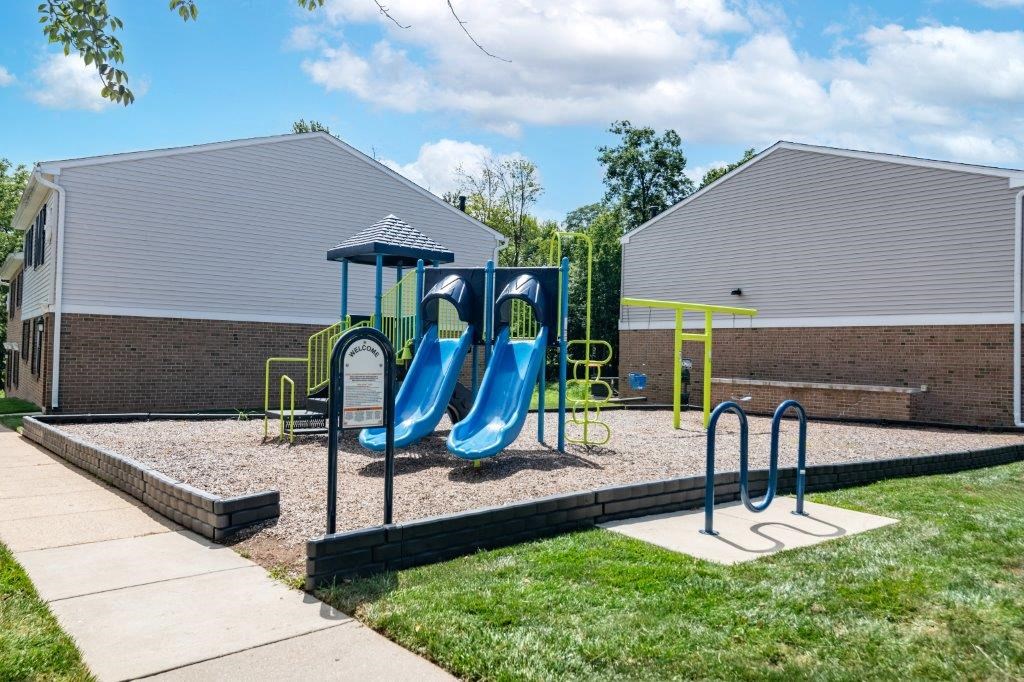 a playground with two slides and a swing set