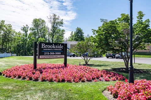 a sign in front of pink flowers