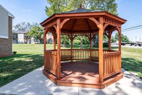 a gazebo with a bench on a sidewalk