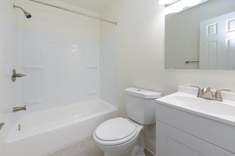 a white bathroom with a toilet and a sink