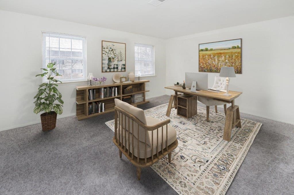 a living room with a desk and a chair