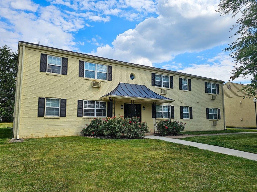 a yellow house with a sidewalk in front of it