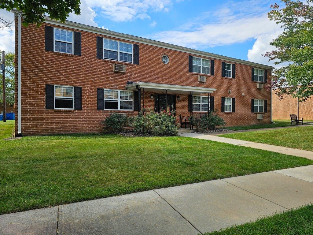 a brick building with a sidewalk in front of it