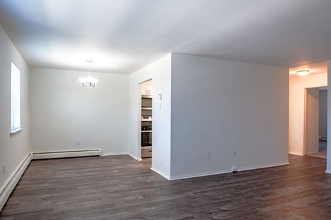 A large empty room with wooden floors and white walls.