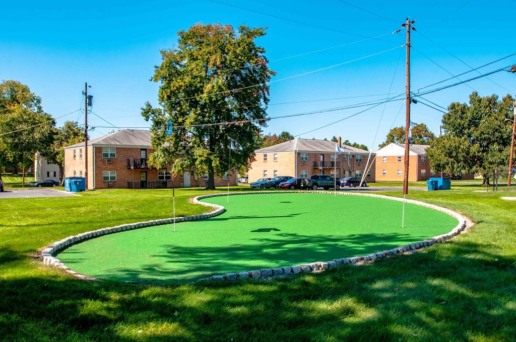 a putting green with houses in the background