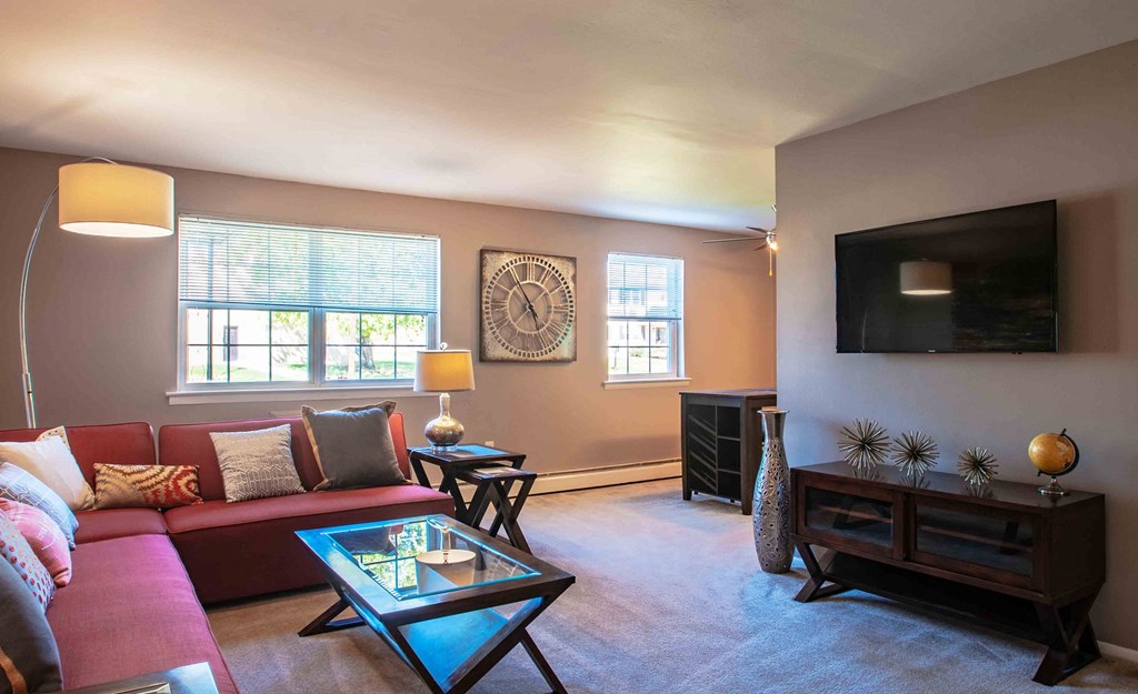 a living room with a red couch and a television
