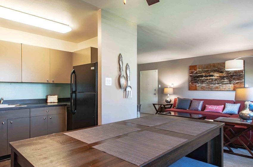 a kitchen and living room with a table and a refrigerator