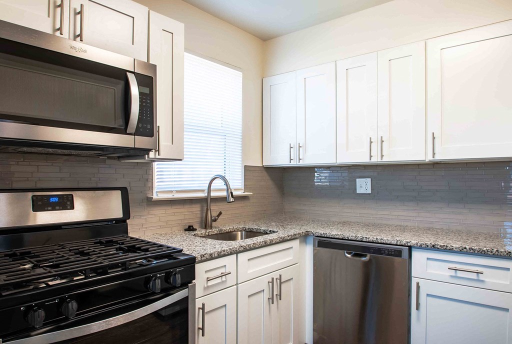 a kitchen with stainless steel appliances and white cabinets