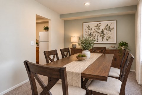 A dining room with a wooden table and chairs.