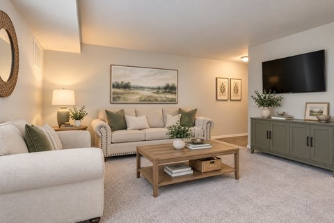 A living room with a white couch, a wooden coffee table, and a painting on the wall.