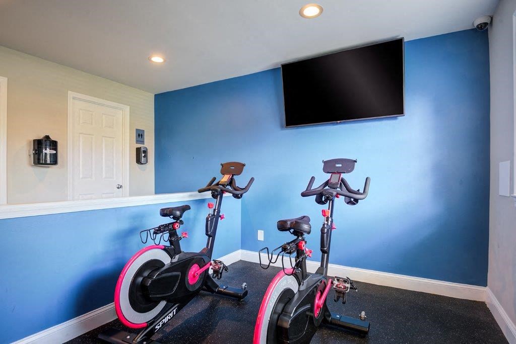 a home gym with exercise bikes and a tv