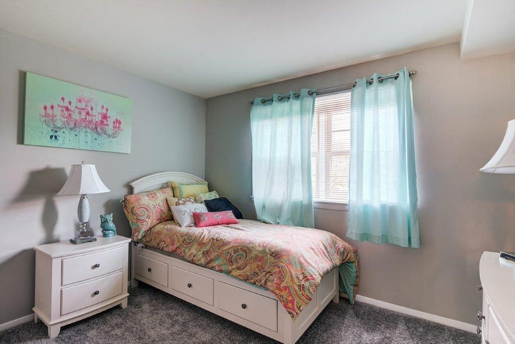 a bedroom with a bed and a window with blue curtains