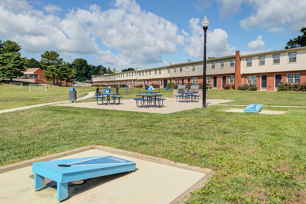 a blue ping pong table in a park in front of a building