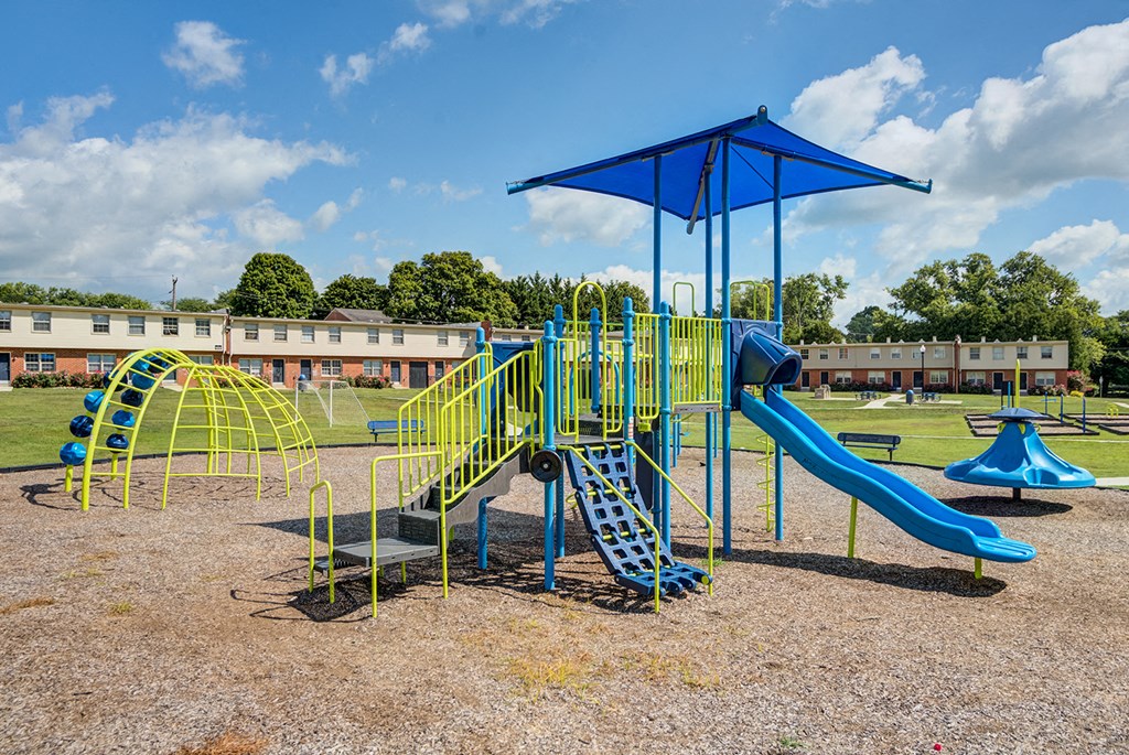 a playground with a swing set and slides at a park