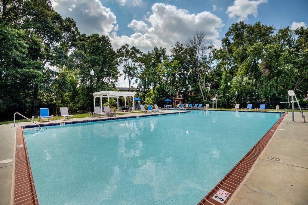 a large swimming pool with trees in the background