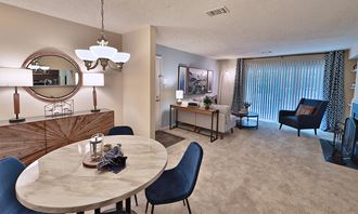 a living room and dining room with a table and chairs