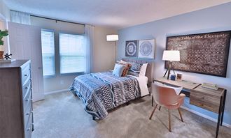 a bedroom with a bed and a desk with a chair