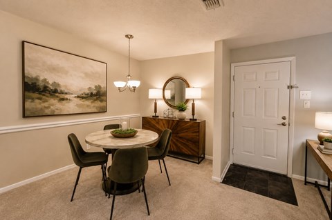 A dining room with a round table and chairs.