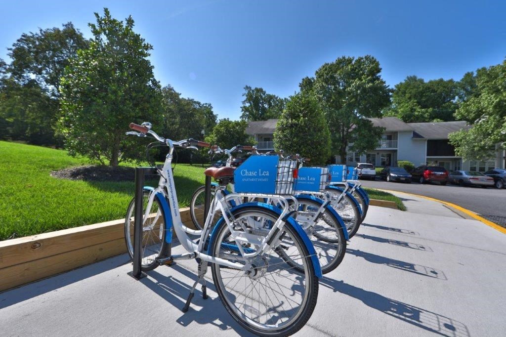 a row of blue bikes parked on a sidewalk