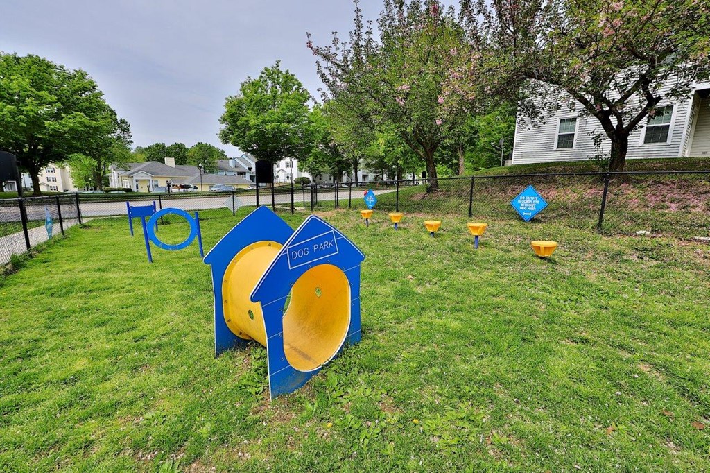 a playground with blue and yellow signs in the grass