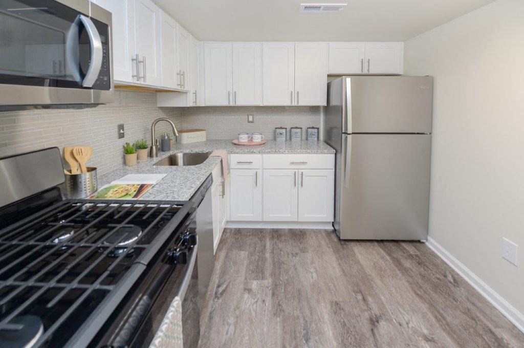 a kitchen with stainless steel appliances and white cabinets