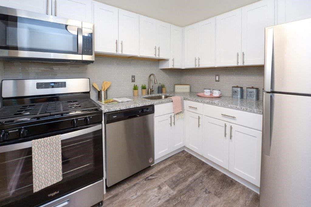 a kitchen with stainless steel appliances and white cabinets