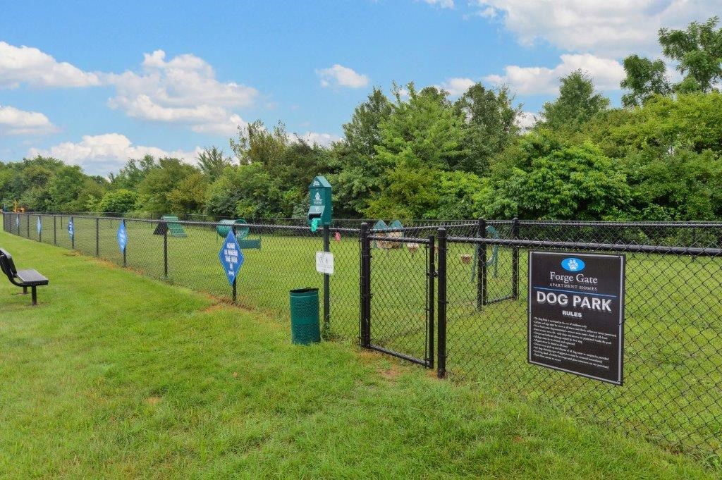 a dog park with a sign on a fence