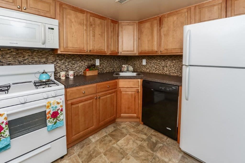 a kitchen with white appliances and wooden cabinets