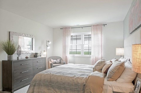 a bedroom with a bed and a dresser and a window
