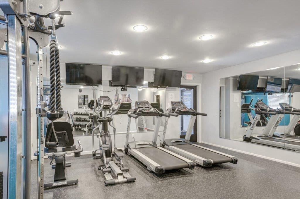 the gym is equipped with cardio machines and televisions