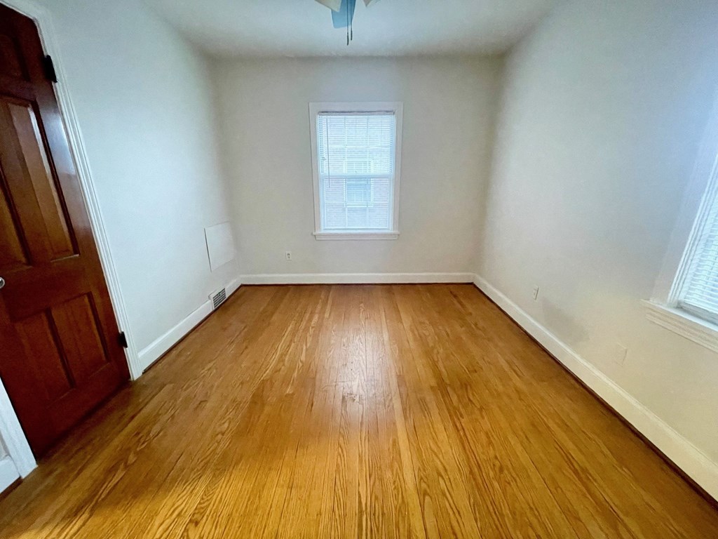 A room with wooden flooring and a window.