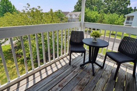 a patio with two chairs and a table on a deck