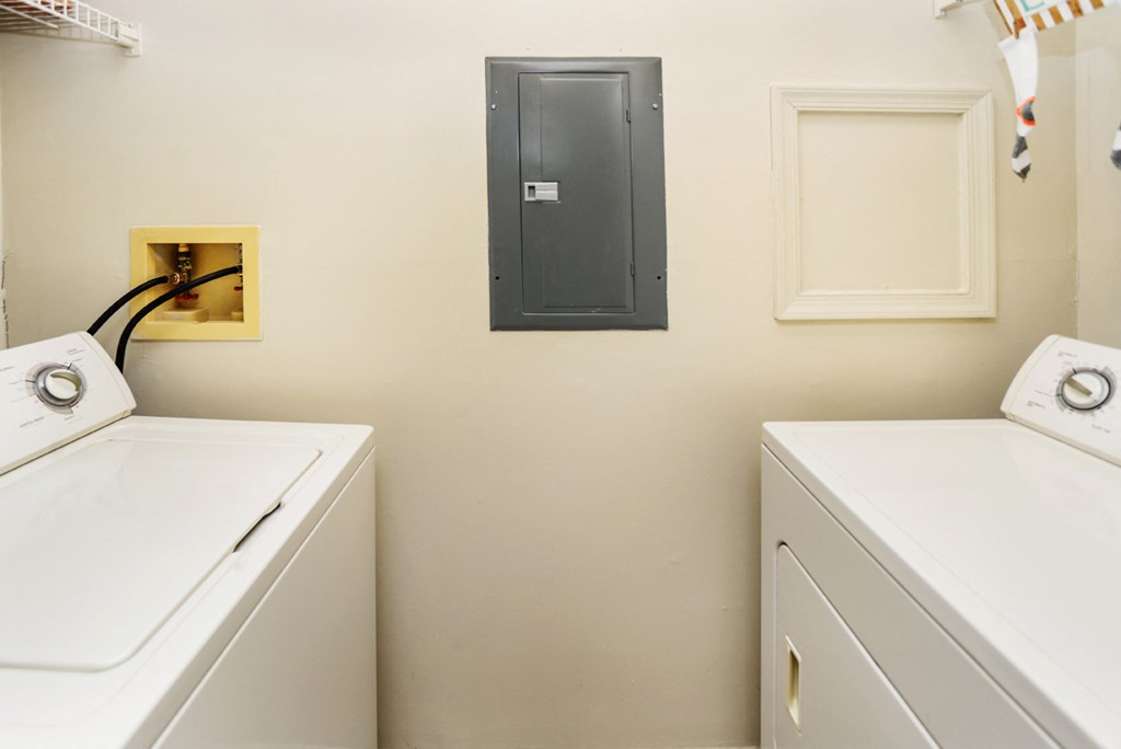 a washer and dryer in a laundry room with a black door