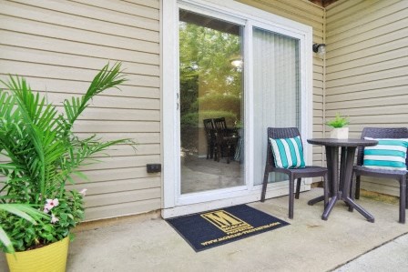 a patio with a table and chairs and a sliding glass door